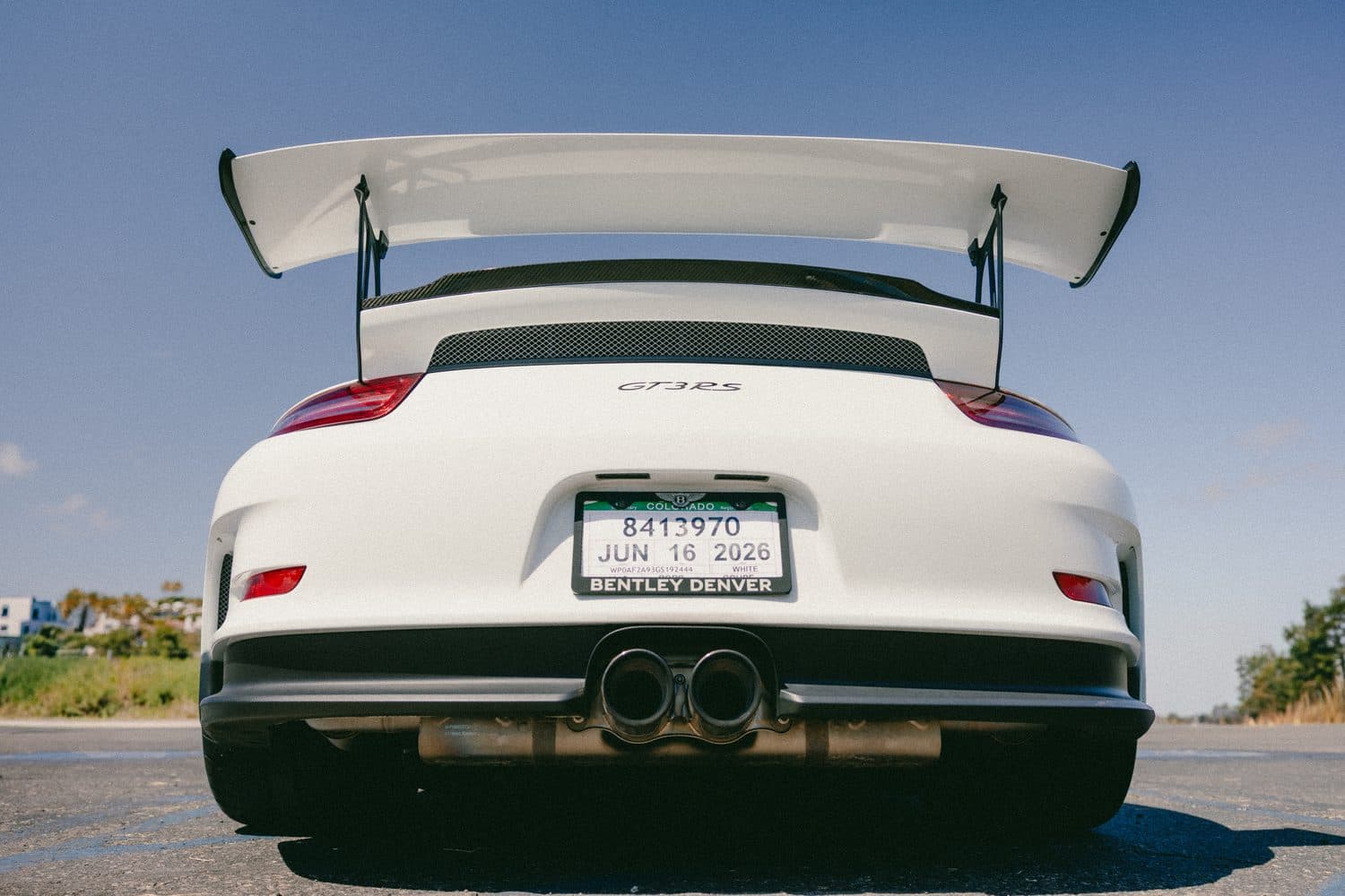 Rear of the white Porsche 911 GT3 RS — large adjustable swan-neck wing, GT3 RS badge and center-exit exhaust